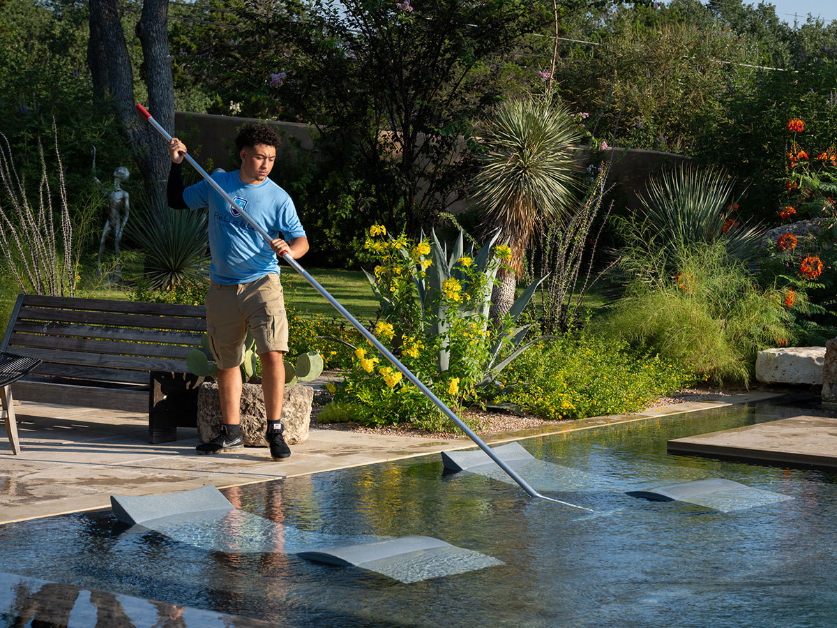 Reliable Pool Care maintenance specialist cleaning a customer's pool